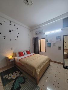 um quarto com uma cama e um relógio na parede em Saigon Cozy House & coffee em Cidade de Ho Chi Minh