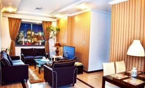 Hotel Leaders Plaza Salmiya في الكويت: غرفة معيشة مع أريكة وطاولة