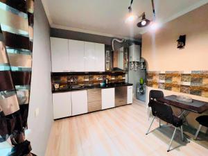 a kitchen with white cabinets and a table in it at Awesome Large 3 Floor Villa Dilijan , 8 Bedrooms+4.5 Bathrooms+Swimming Pool, Nice Mountain View in Dilijan