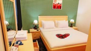 a bedroom with a bed with a heart on it at Hotel Leaders Plaza Salmiya in Kuwait