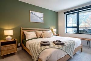 a bedroom with a large bed and a window at Revy Bliss - Dazzling Condo in the Mountains in Revelstoke