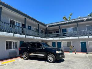 a black suv parked in front of a building at Sahara Inn - Los Angeles in Los Angeles