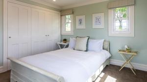 a bedroom with a large bed with white sheets at Somerleyton Cottage in Wildes Meadow