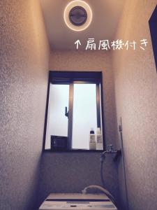 うるま市にあるguesthouse みつばのバスルーム(鏡、洗面台付)、窓が備わります。