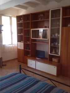 1 dormitorio con armarios de madera y 1 cama. en Appartamenti Claudia Rio, en Rio Marina