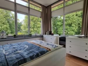 1 dormitorio con ventanas grandes y 1 cama grande en Meerblick-am Strand, im Kurpark!, en Glücksburg