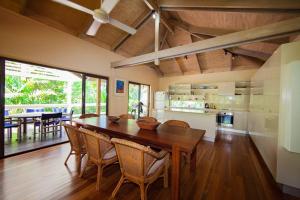 Il comprend une cuisine et une salle à manger avec une table et des chaises en bois. dans l'établissement Breeya - A great tropical escape. Sleeps 9, à Mission Beach