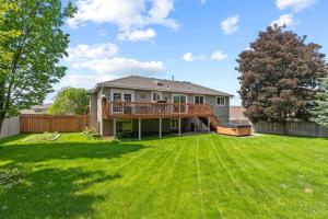 a house with a large yard with a deck at Hot tub! Sleeps 8-11Upscale Area in Spokane