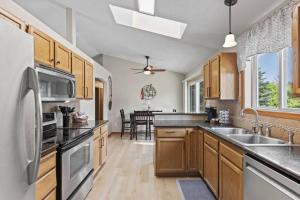 a kitchen with wooden cabinets and a stainless steel refrigerator at Hot tub! Sleeps 8-11Upscale Area in Spokane