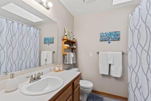 a bathroom with a sink and a toilet and a mirror at Hot tub! Sleeps 8-11Upscale Area in Spokane +32 photos
