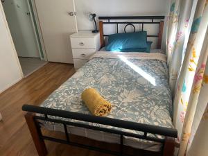 um pequeno quarto com uma cama com uma almofada azul em Single room share bathroom and kitchen em Perth