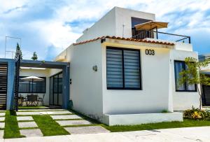 a white house with a patio in the backyard at Casa con alberca, coto privado, gran ubicacíon in Puerto Vallarta