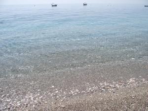 a sandy beach with two boats in the water at B&B Il Mare degli Dei in Letojanni