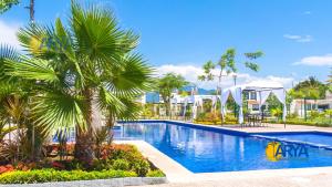 a pool at a resort with palm trees and buildings at Casa con alberca, coto privado, gran ubicacíon in Puerto Vallarta