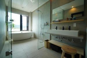 La salle de bains est pourvue d'une baignoire, d'un lavabo et d'une douche. dans l'établissement Villacation the Loose, à Minamiawaji
