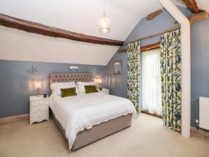 a bedroom with a large bed with blue walls at Green Farm Stables in Ashbourne