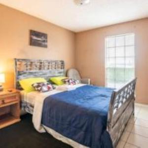 sypialnia z łóżkiem z niebieską pościelą i żółtymi poduszkami w obiekcie Lovely 2- bedroom apartment with nice amenities w mieście Houston