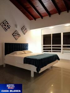 a bedroom with a bed in a room with a window at Hotel Boutique Casa Blanca Zarzal in Zarzal