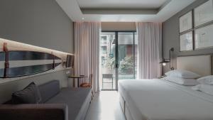 a bedroom with a large white bed and a couch at Sugar Marina Hotel-SURF-Kata Beach in Kata Beach