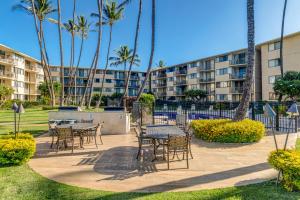 a patio with tables and chairs in front of a building at Kanai A Nalu 214 in Wailuku