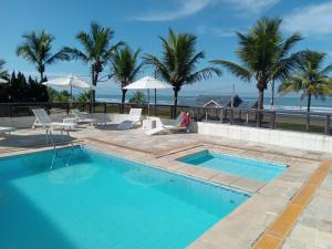 a swimming pool with a view of the ocean at Ancora Peruibe Hotel in Peruíbe