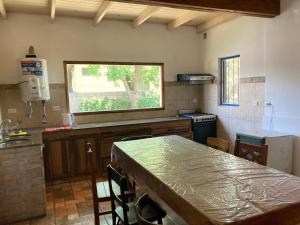 cocina con mesa y ventana en Alojarte en Punilla- Casona Azul hasta 12 personas en Huerta Grande