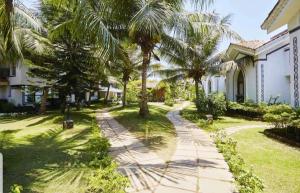 a walkway in front of a house with palm trees at Luxury Stay at GOA in Anjuna