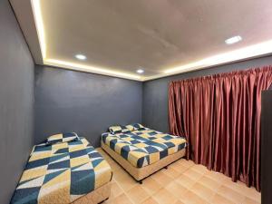 2 Betten in einem Zimmer mit roten Vorhängen in der Unterkunft BESLA HOMESTAY LOT986 at A'Famosa Resorts Melaka Villa, 5rooms, private pool, BBQ, KARAOKE with surcharge in Malakka