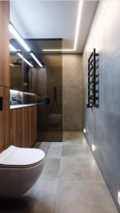 a bathroom with a toilet and a sink and a shower at Feel in forest in Vilnius