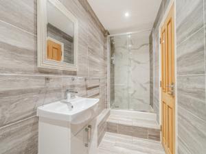 a white bathroom with a sink and a shower at The Annexe At Moulton Grange in Brixworth