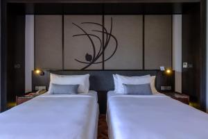two beds sitting next to each other in a room at Lone Pine, Penang, a Tribute Portfolio Resort in Batu Ferringhi