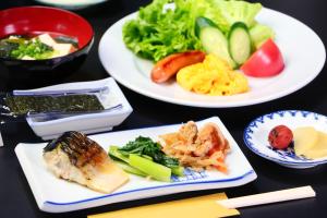 three plates of food on a table with vegetables at 民宿やまそ in Takashima