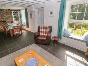 uma sala de estar com uma mesa e uma cadeira em Briar Cottage em Neyland