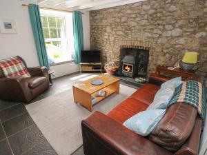 a living room with a couch and a fireplace at Briar Cottage in Neyland