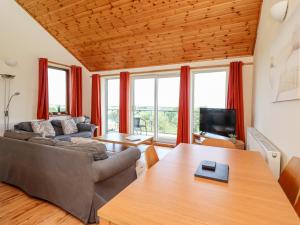 恩布爾頓的住宿－Dunstanburgh View，客厅配有沙发和桌子