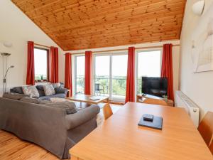 a living room with a couch and a table at Dunstanburgh View in Embleton