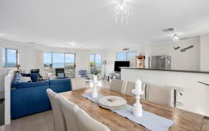 ein Wohnzimmer mit einem Tisch und einem blauen Sofa in der Unterkunft Moet Escape in Style in Encounter Bay