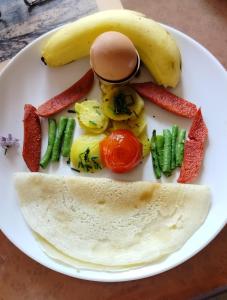 un plato de comida con un huevo y verduras en COMMUNITY HOLIDAY INN en Panauti