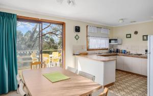 a kitchen and dining room with a table and a window at Comfortable Elevated Holiday Home in Encounter Bay