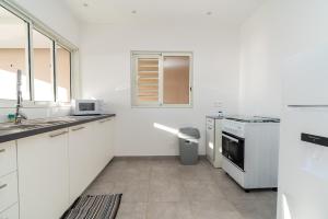 - une cuisine blanche avec évier et cuisinière dans l'établissement Fare Taharaa 1BR in Arue, à Arue