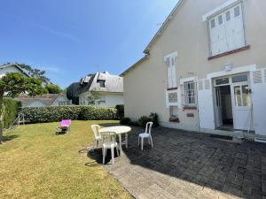 une terrasse avec une table et des chaises devant une maison dans l'établissement Maison Cabourg, 6 pièces, 10 personnes - FR-1-794-86, à Cabourg