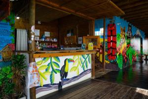 a restaurant with a counter with a bird painted on the wall at Hostal Sierra Minca in Minca