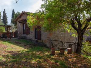 a small stone house with a tree in the yard at Farmhouse in Castelfranco Piandisc with Garden in Castelfranco di Sopra