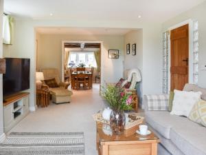 a living room with a couch and a tv at Hoopers End in Sedgwick