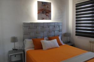 um quarto com uma cama com um cobertor laranja em Apartment in the city of Olot Penthouse em Olot
