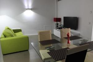 uma sala de estar com um sofá verde e uma mesa de vidro em Apartment in the city of Olot Penthouse em Olot