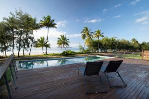 - deux chaises assises sur une terrasse à côté d'une piscine dans l'établissement Bella's Beach House - Family Home - South Mission Beach, à South Mission Beach