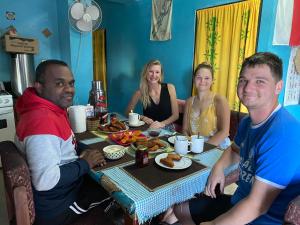 un grupo de personas sentadas alrededor de una mesa comiendo comida en Save's Homestay en Nadi