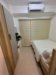 - une petite chambre avec un lit et une télévision au plafond dans l'établissement Munting Tahanan sa Tagaytay, à Tagaytay