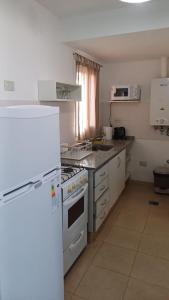 a kitchen with a white stove and a refrigerator at tu lugar 2 in Córdoba